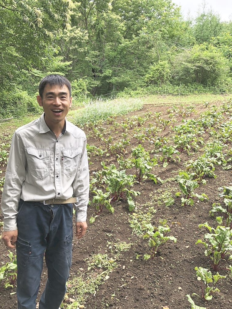ファームさいかち:畑に立つファームさいかちの生産者