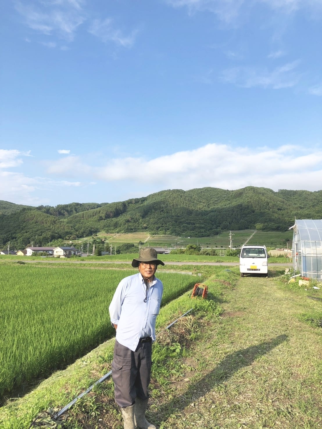 両角農園:水田のそばに立つ両角農園の生産者