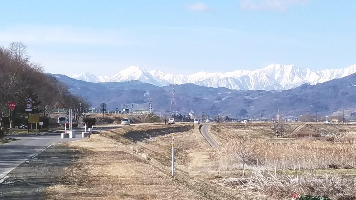 大地の卵:雪をいただく山々と田畑の風景